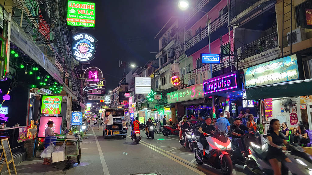 Busy nighttime street scene along Soi Buakhao lined with neon signs, bars, and motorbikes, illustrating where to stay in Pattaya for budget accommodation.